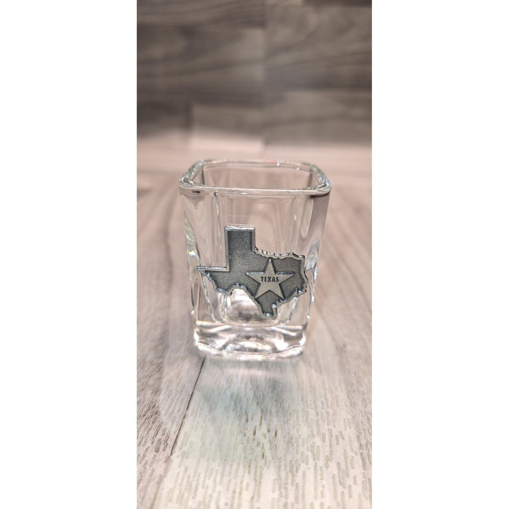 square souvenir shot glass W/ a pewter-style metal emblem of the state of Texas